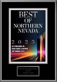 A framed certificate reads "Best of Northern Nevada 2023" in bold text, with "As Published in Reno News & Review September 2023" below. The bottom section has a smaller plaque with partially obscured text. In the background, colorful light streaks add a vibrant touch to this esteemed veterinarian award.