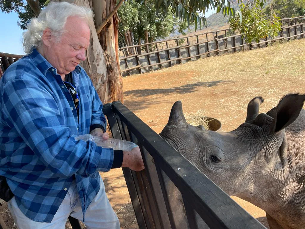 Dr. Mark Newkirk VMD feeding a rhinoceros during international wildlife conservation volunteer work